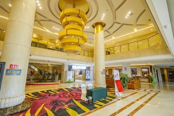 A spacious lobby with a central staircase, a reception desk, and a patterned carpet. - Haocheng International Hotel (Sanyuan)