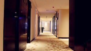 A long, narrow hotel corridor with a patterned carpet and dark wooden doors on both sides. - Haocheng International Hotel (Sanyuan)