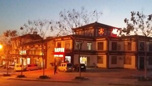 A multi-story building with signage for a restaurant and a hotel. - Apollo Hotel, South Guizhou (Yinan)