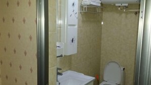 A bathroom with a toilet, sink, and towel rack. - Apollo Hotel, South Guizhou (Yinan)