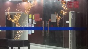 A hotel entrance with a glass door, interior signage, and a blue stripe across the door. - Haiyan Guyun Inn (Haiyan)