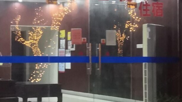 A hotel entrance with a glass door, interior signage, and a blue stripe across the door. - Haiyan Guyun Inn (Haiyan)