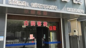 A hotel entrance with a glass door, signage indicating it is a hotel, and a contact number. - Haiyan Guyun Inn (Haiyan)