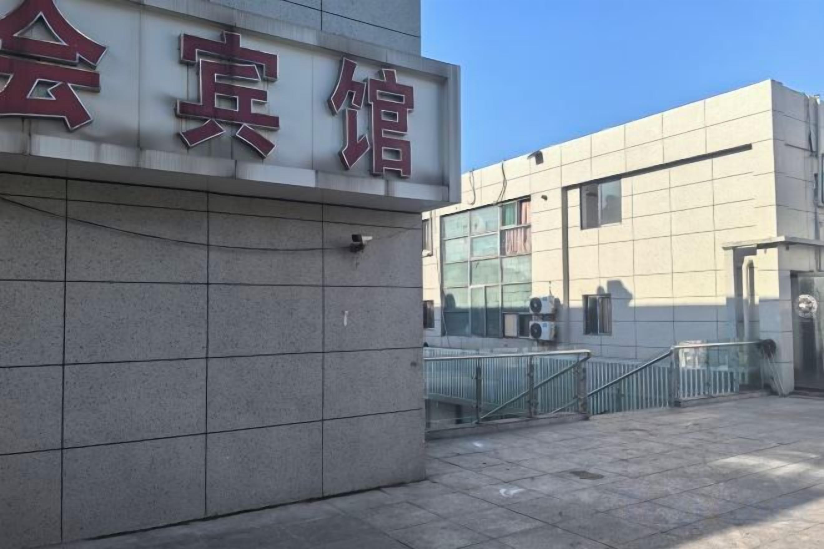 A building with a sign that reads '会宾馆' and a gated entrance.