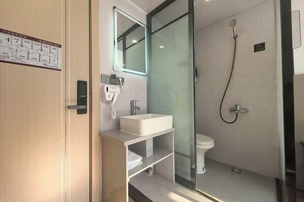 A modern bathroom with a glass shower enclosure, a white sink, and a toilet. - Ningbo Jinhui Business Hotel (Ningbo)