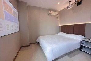 A hotel room with a bed, a nightstand, an air conditioning unit, and a projector mounted on the ceiling. - Ningbo Jinhui Business Hotel (Ningbo)