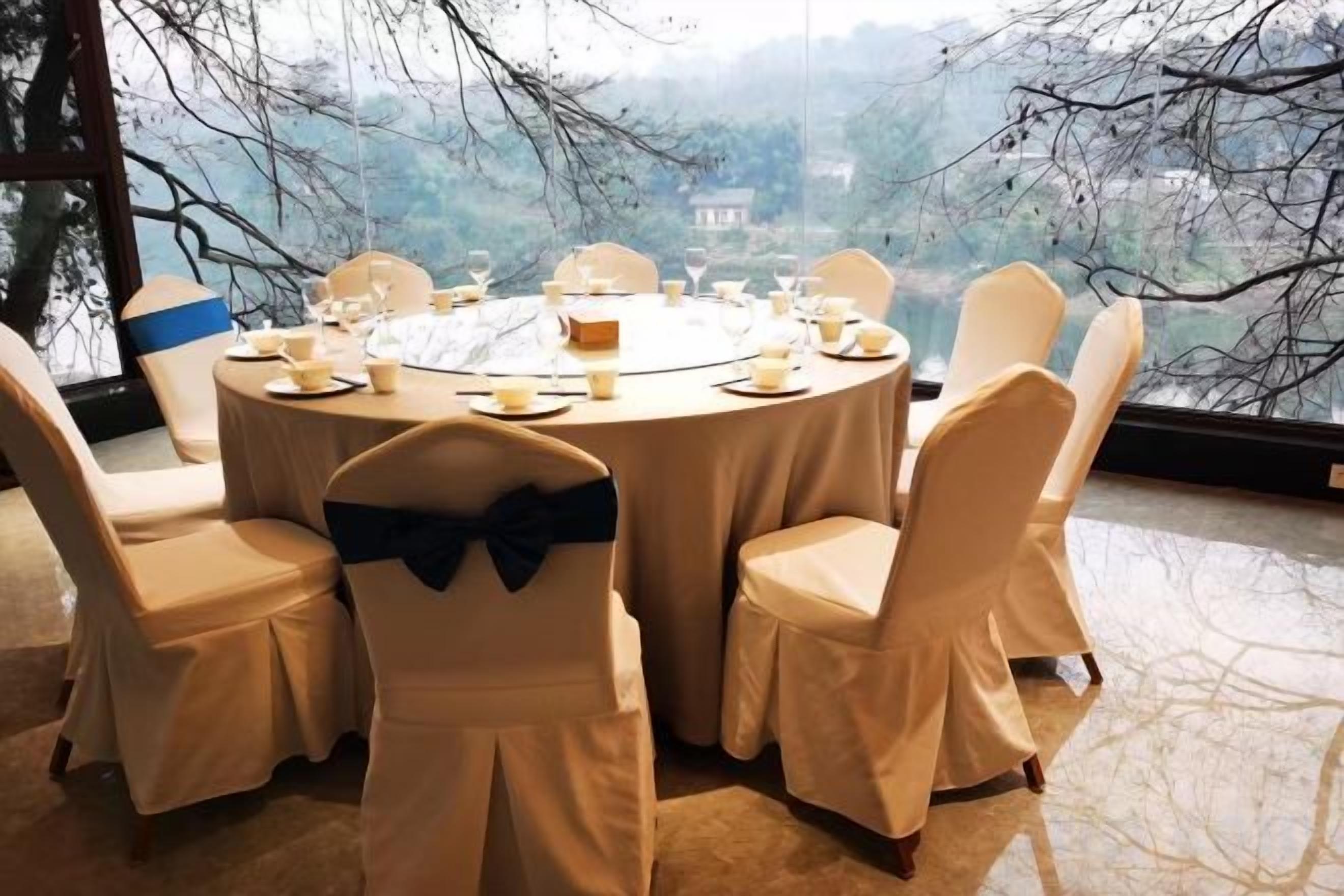 A round dining table with chairs, set for a meal.