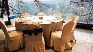A round dining table with chairs, set for a meal.