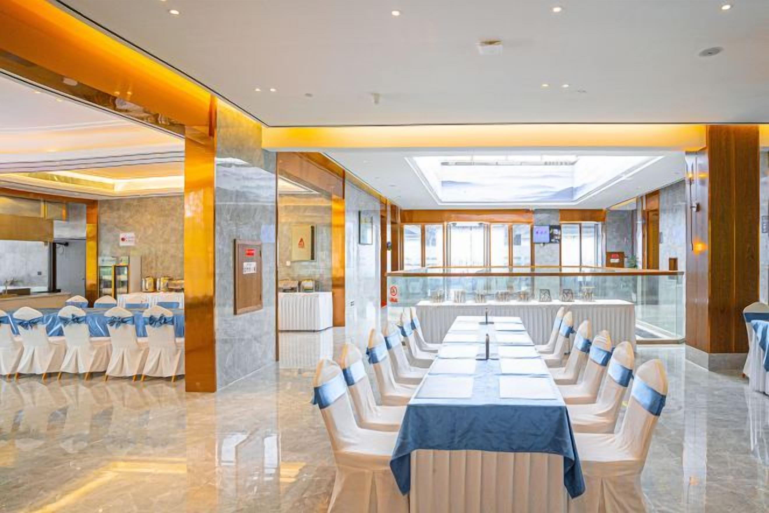 Un salón de conferencias con una larga mesa y sillas, una recepción y vistas al vestíbulo.