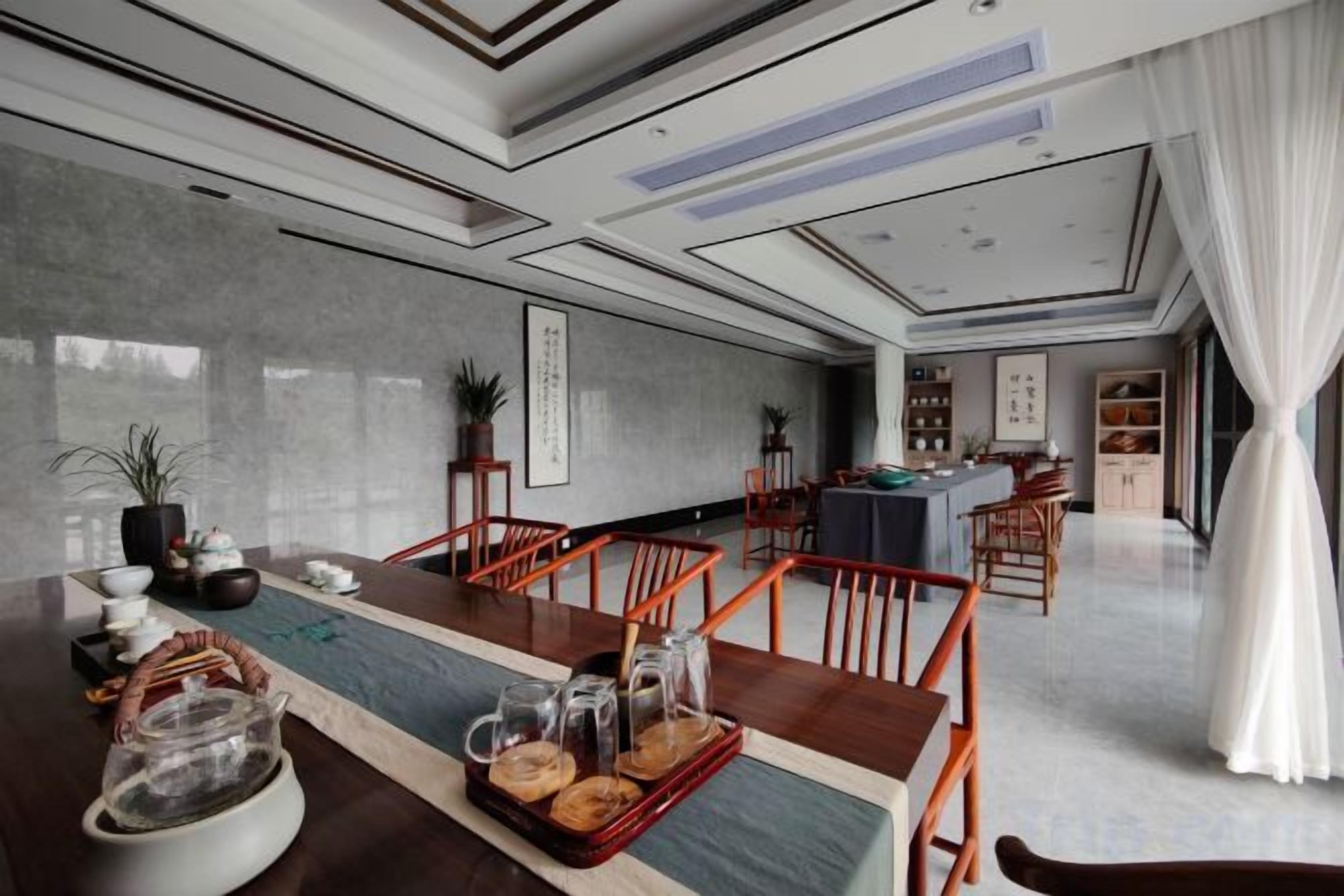 Un comedor amplio con una mesa larga, sillas y una cocina al fondo.
