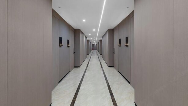 Un lungo corridoio stretto con una fascia luminosa al centro e porte su entrambi i lati.