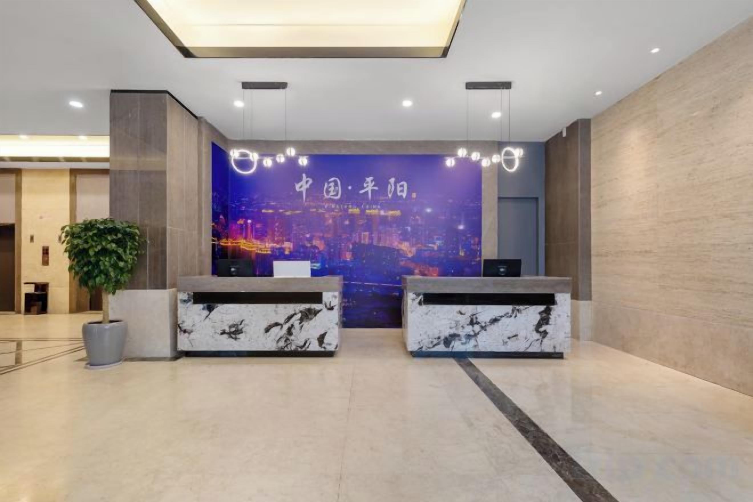 A reception area with two marble reception desks, a large cityscape poster, and a potted plant.