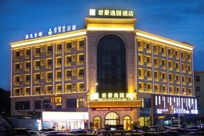 A multi-story hotel with a prominent entrance and signage indicating it is a hotel. - Sovereign Garden Hotel (Cangnan)