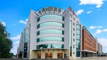A multi-story hotel with a curved facade, large windows, and a prominent entrance.