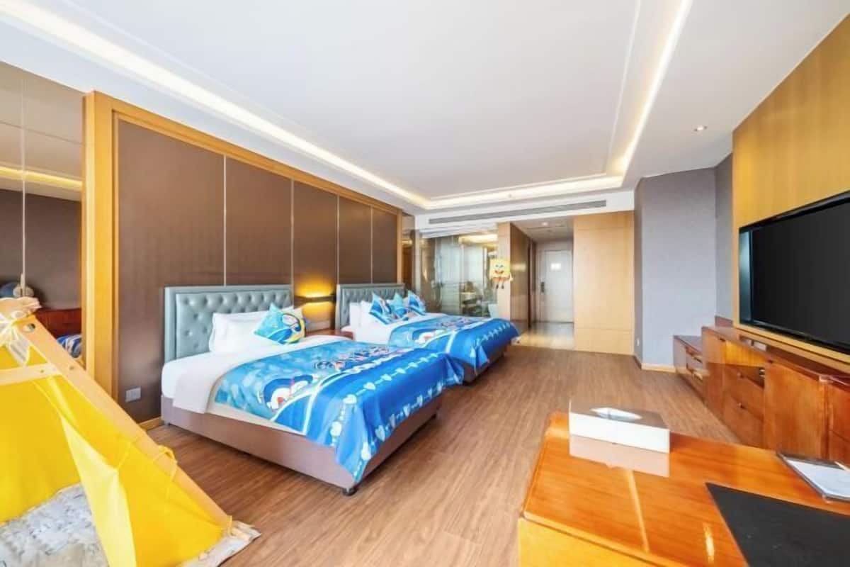 Ein Hotelzimmer mit einem großen Bett, einem Fernseher, einem Holztisch und einer zeltartigen Konstruktion.