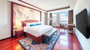 A hotel room with a large bed, a desk, a chair, a television, and a window with a city view. - Pujing Weiting Hotel (Jinkunqiao) (Tianjin)