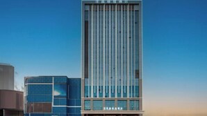 A modern building with a vertical design, featuring a prominent entrance and a clear sky in the background. - Pujing Weiting Hotel (Jinkunqiao) (Tianjin)