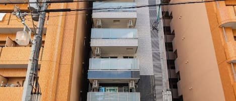 A multi-story building with balconies and a central staircase.