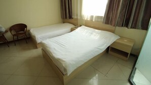 A hotel room with two single beds, a wooden chair, a small bedside table, and a window with curtains. - Jiajian Hostel (Shanghai)