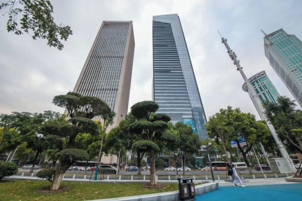 Dos edificios altos con un parque al frente.