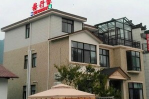 Un immeuble à plusieurs étages, doté d’un toit plat, de grandes fenêtres et d’un balcon situé à l’étage supérieur.