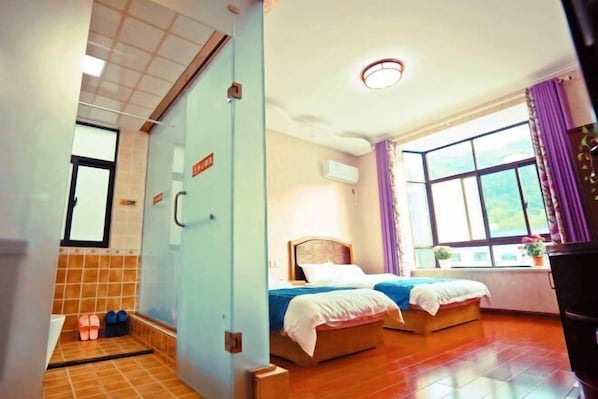 Une chambre d’hôtel avec deux lits, une fenêtre avec des rideaux, un sol carrelé et une salle de bain visible.