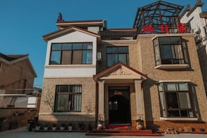 A two-story building with a prominent entrance, large windows, and a balcony. - Ningguo Travellers Homestay (Ningguo)