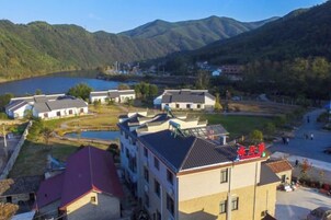 A residential area with multiple buildings, a lake, and mountains in the background.