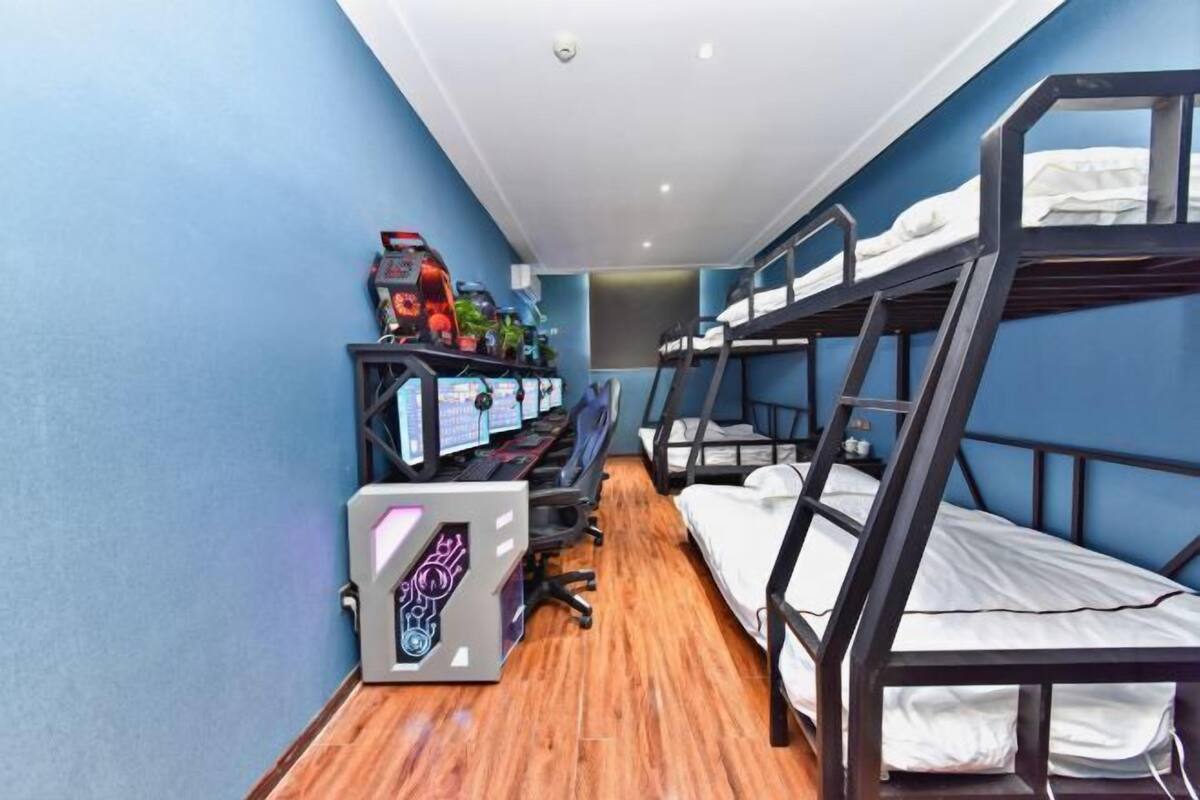 Une chambre avec un lit superposé, un bureau et un ordinateur.