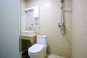 Ein kleines Badezimmer mit Toilette, Waschbecken und Dusche.