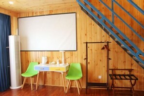 A room with a wooden interior, a desk with a chair, a projector screen, and a staircase. - Time Inn (Linjiang Branch, Shiwei Town, Erguna) (Ergun)