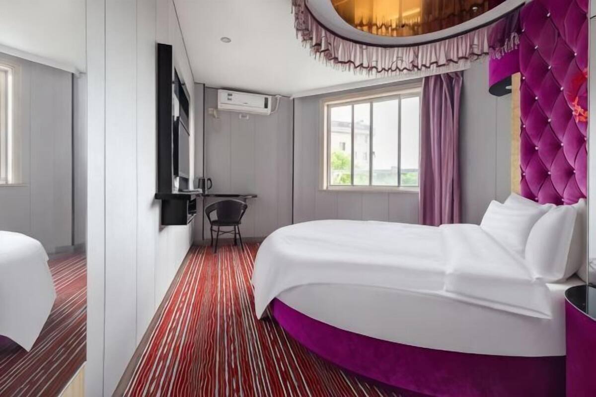 A hotel room with a bed, a desk, and a chair.
