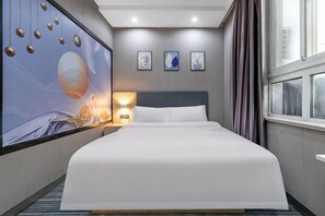 A hotel room with a large bed, a wall-mounted artwork, a bedside table with a lamp, and a window with curtains. - 100 Inn Liangpin Hotel (Shanghai Waigaoqiao Gongcheng Road Subway Station) (Shanghai)
