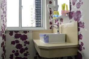 A bathroom with a sink, a window, and a shelf with toiletries. - 100 Inn Liangpin Hotel (Shanghai Waigaoqiao Gongcheng Road Subway Station) (Shanghai)