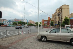 A street view with a parked car, buildings, and a pedestrian crossing. - 100 Inn Liangpin Hotel (Shanghai Waigaoqiao Gongcheng Road Subway Station) (Shanghai)