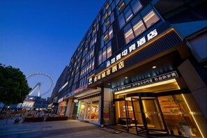 Een hotel met een moderne gevel, grote glasramen en een opvallende ingang.