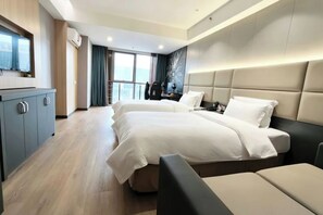 Een moderne hotelkamer met een groot bed, een bureau, een televisie en uitzicht over de stad.