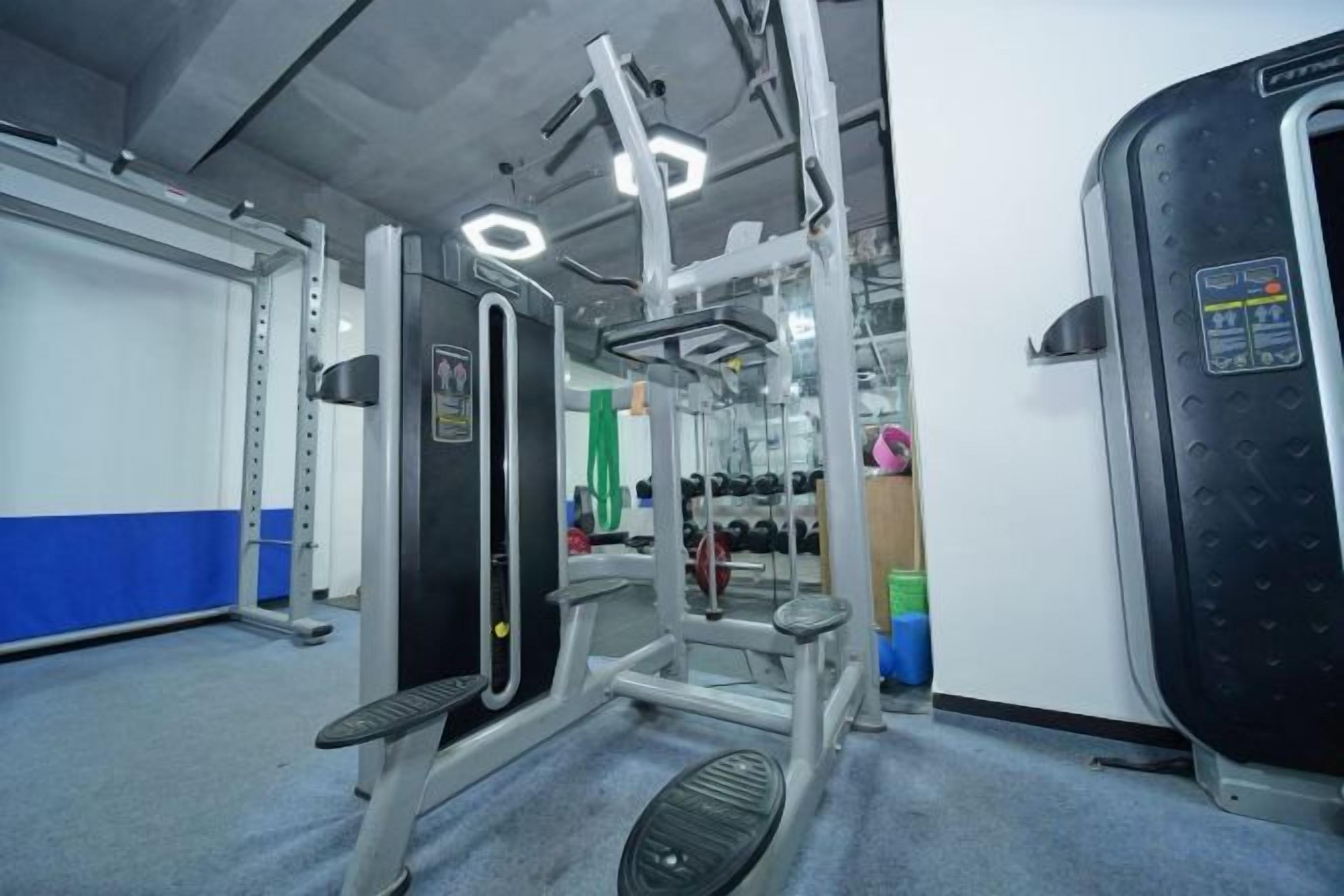 A gym with exercise equipment, a mirror, and a weight rack.