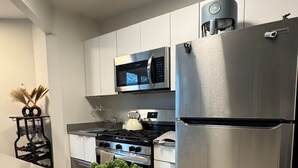 Une cuisine moderne équipée d’appareils électroménagers en acier inoxydable, d’un four à micro-ondes et d’un réfrigérateur.