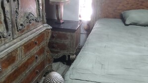 A bedroom with a bed, a dresser, a lamp, and a decorative mirror. - Cozy 1-bedroom house in beautiful Orlando with AC (Orlando)