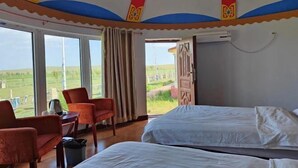 Una habitación con una cama, una silla, una mesa y una ventana con vistas al exterior.