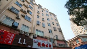 A multi-story building with several commercial establishments on the ground floor. - Longyang Inn (Shanghai)
