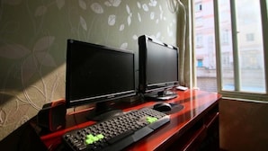 A computer setup with two monitors on a desk, a keyboard, and a mouse. - Longyang Inn (Shanghai)