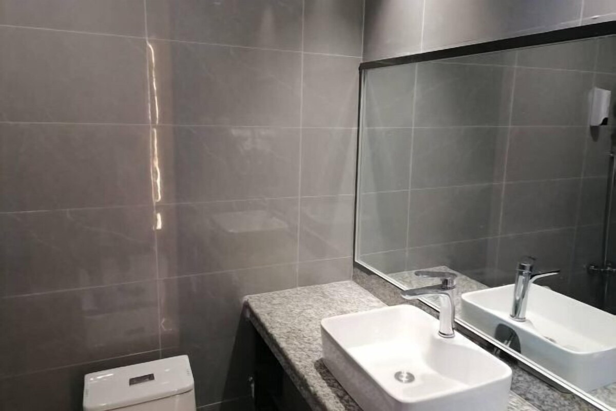 Une salle de bain moderne avec deux lavabos, un grand miroir et des toilettes.