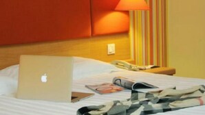 A hotel room with a bed, a laptop, a phone, and a lamp. - Home Inn (Beijing apple garden subway station store) (Beijing)