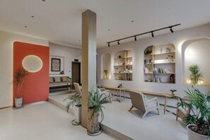 A modern interior with a central column, seating area, and bookshelves.