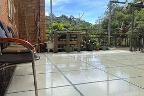 A tiled patio area with a bench, potted plants, and a pergola structure. - Jianfengling Tianchi Mountain Resort (Ledong)