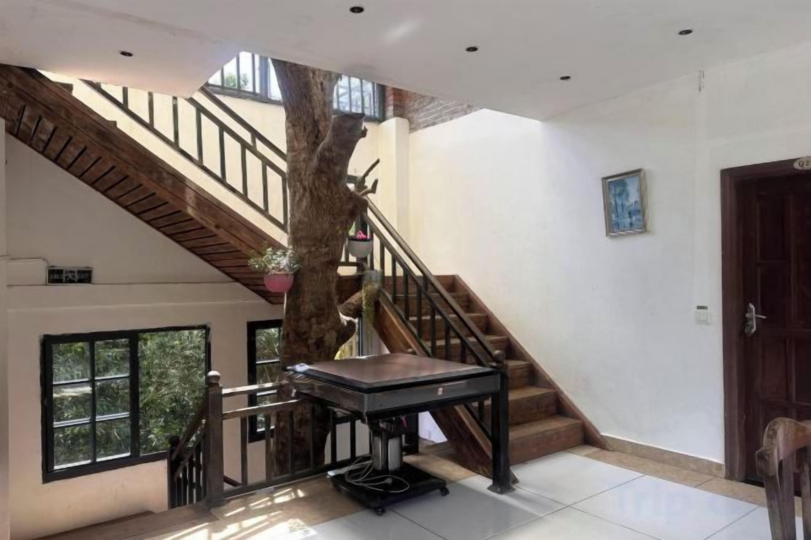 A spacious interior with a staircase, a table, and a door.