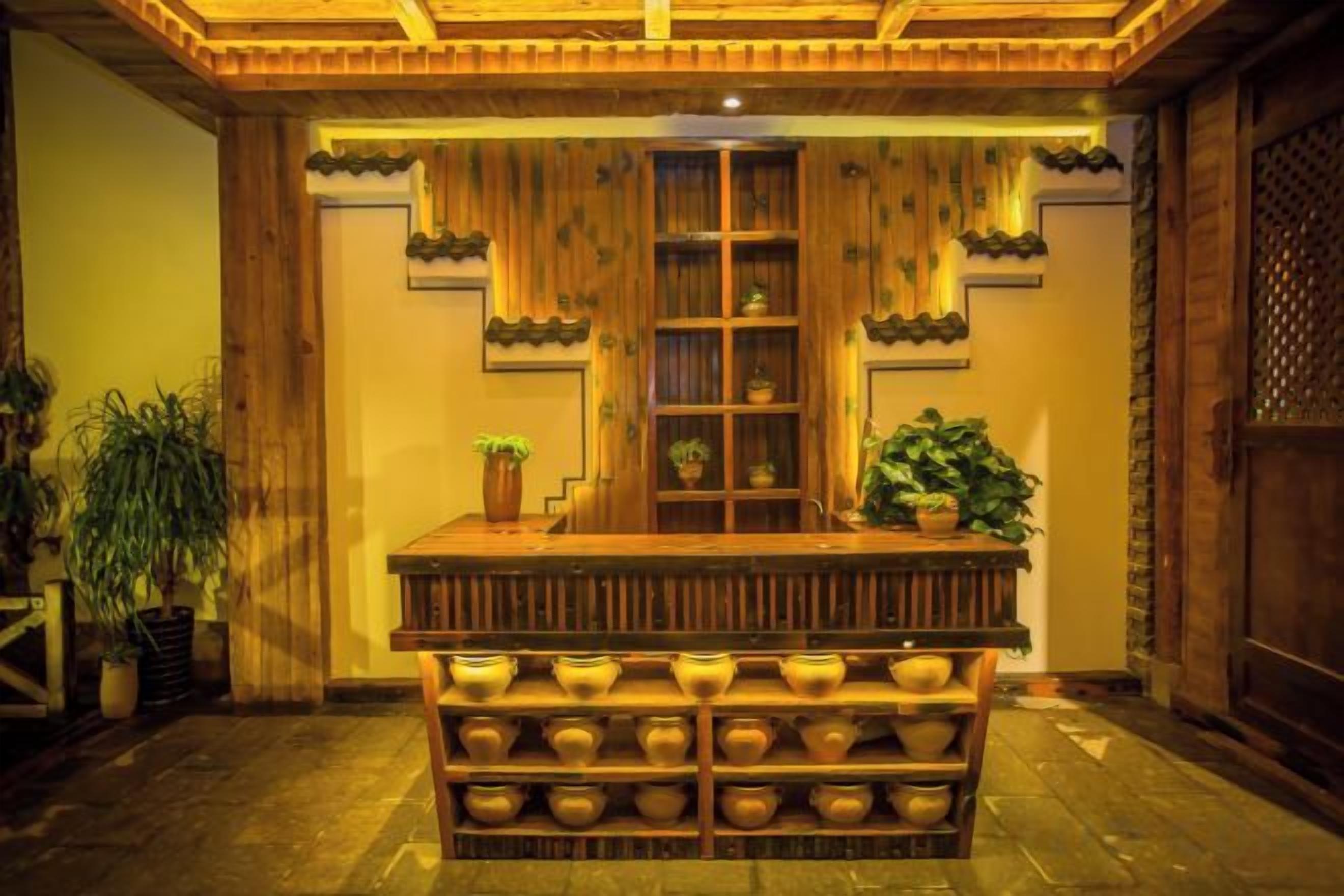 Un área de recepción con un mostrador de madera, estanterías con plantas y una serie de cuencos dispuestos al frente.