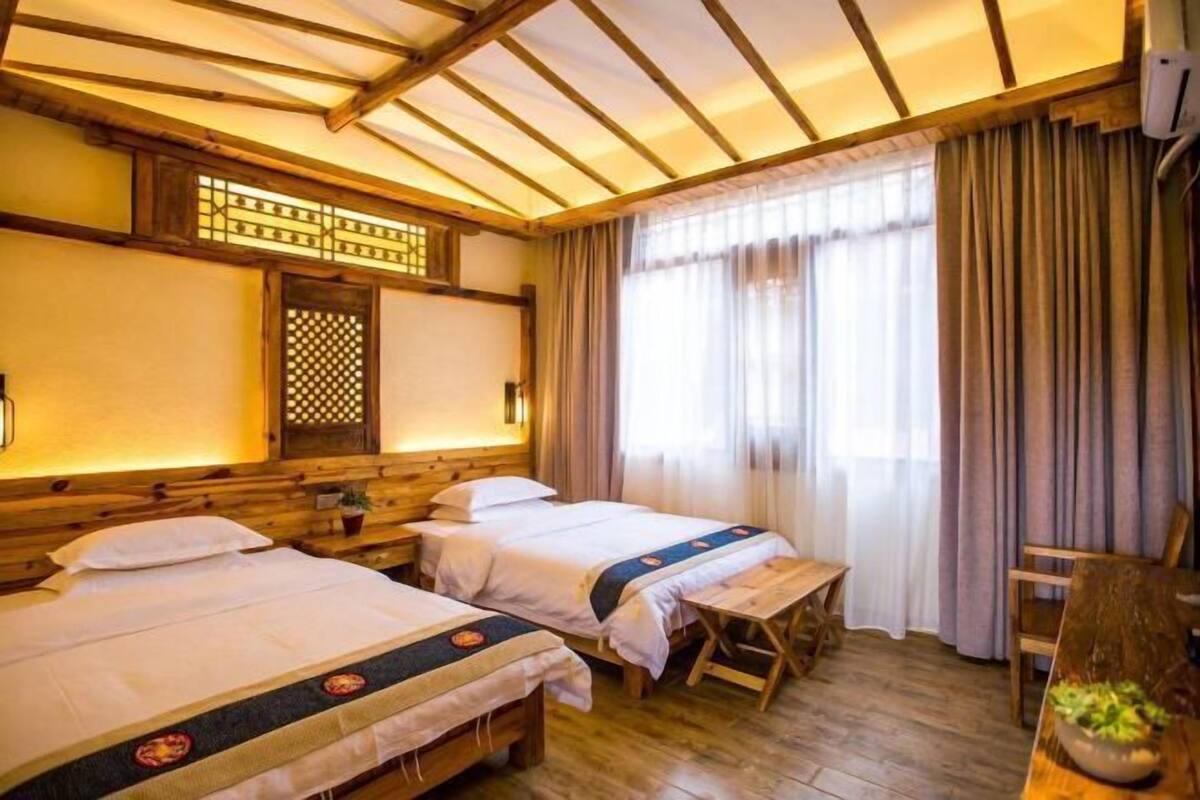 Perinteinen japanilaistyylinen huone, jossa on kaksi sänkyä, puulattia, tatami-matto ja shoji-liukuovi.